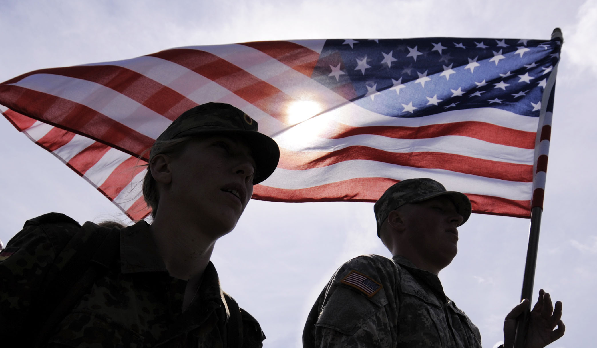 Sergeant Tanja Hoess of German Bundeswehr, left, and Privat Ian Soos of the U.S. Army, right, march with the U.S. flag during the Patrouille  Hlidka  Euregio  Egrensis (PHEE) 2011 International Military Exercise of soldiers from the Armed Forces of the Czech Republic, German Bundeswehr and US Army in Gera, central Germany, on Thursday, June 23, 2011. Some 50 professional soldiers and military reserves will be divided into mixed international teams to fulfil several tasks. (AP Photo/Jens Meyer)